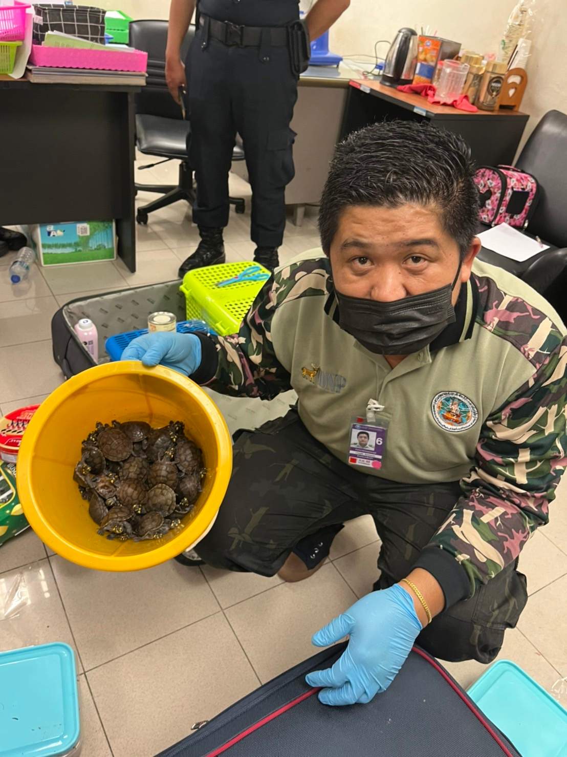 An airport security officer in Bangkok, Thailand shows a basket of turtles recovered from the luggages of two women engaged in wildlife trafficking.