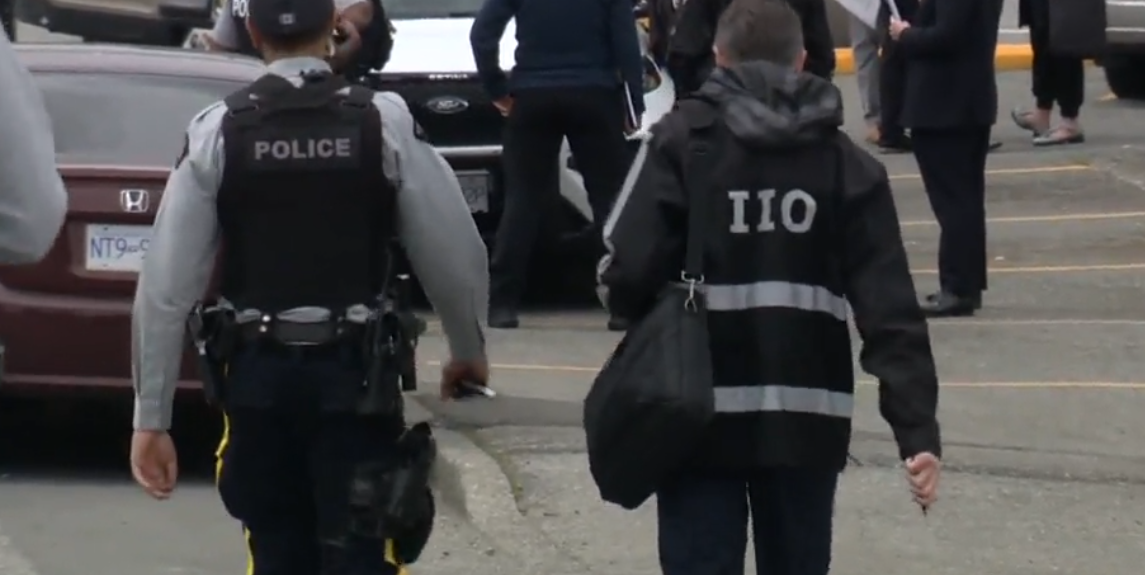 An IIO investigator and RCMP officer are seen in this undated file photo.