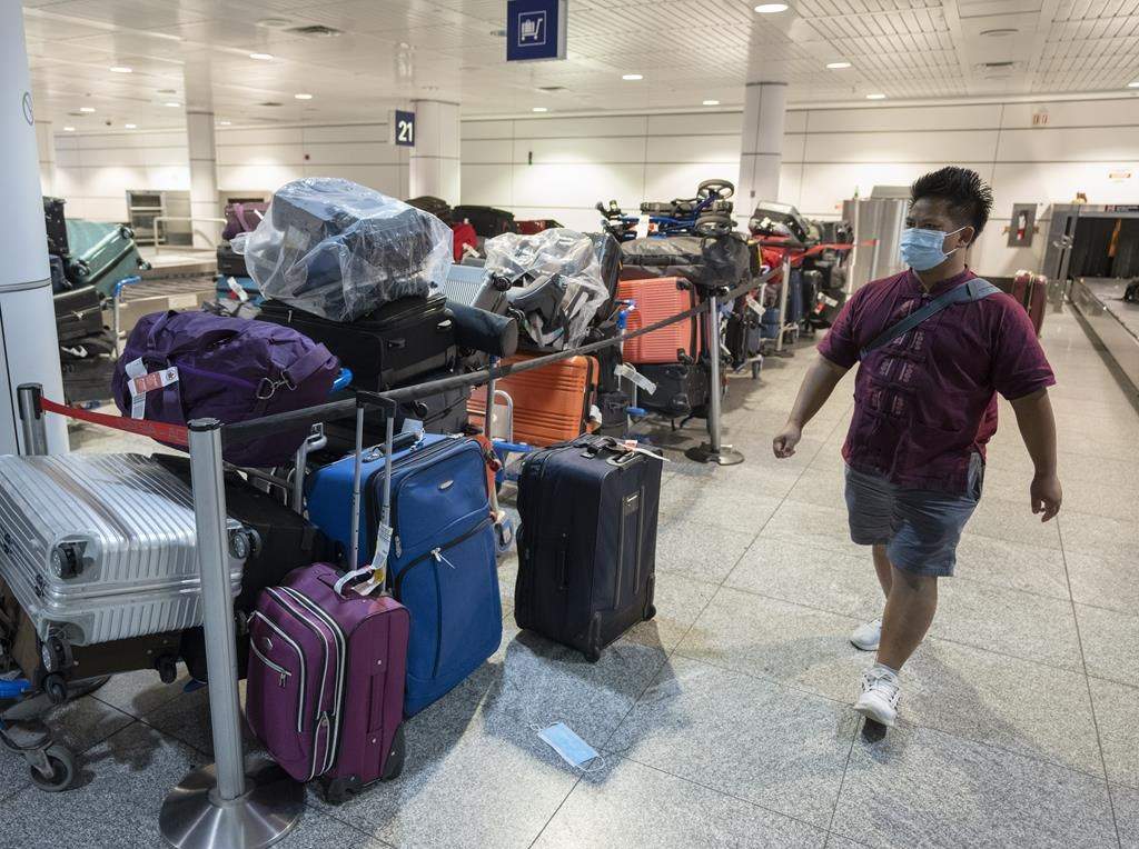 A passenger looks for his luggage among a pile of unclaimed baggage at Pierre Elliott Trudeau airport, in Montreal on June 29, 2022.