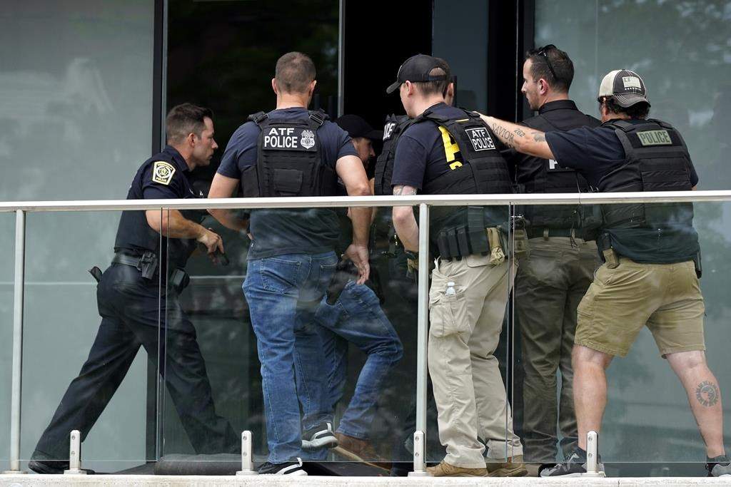 Law enforcement search as they walk into a building after a mass shooting at the Highland Park Fourth of July parade in downtown Highland Park, Ill., a Chicago suburb on Monday, July 4, 2022.