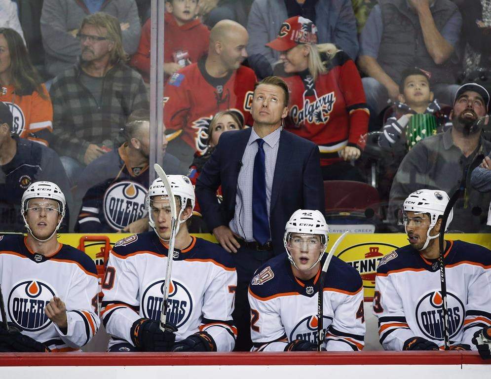 Edmonton Oilers' assistant coach Glen Gulutzan looks to the scoreboard during first period preseason NHL hockey action in Calgary, Monday, Sept. 17, 2018.