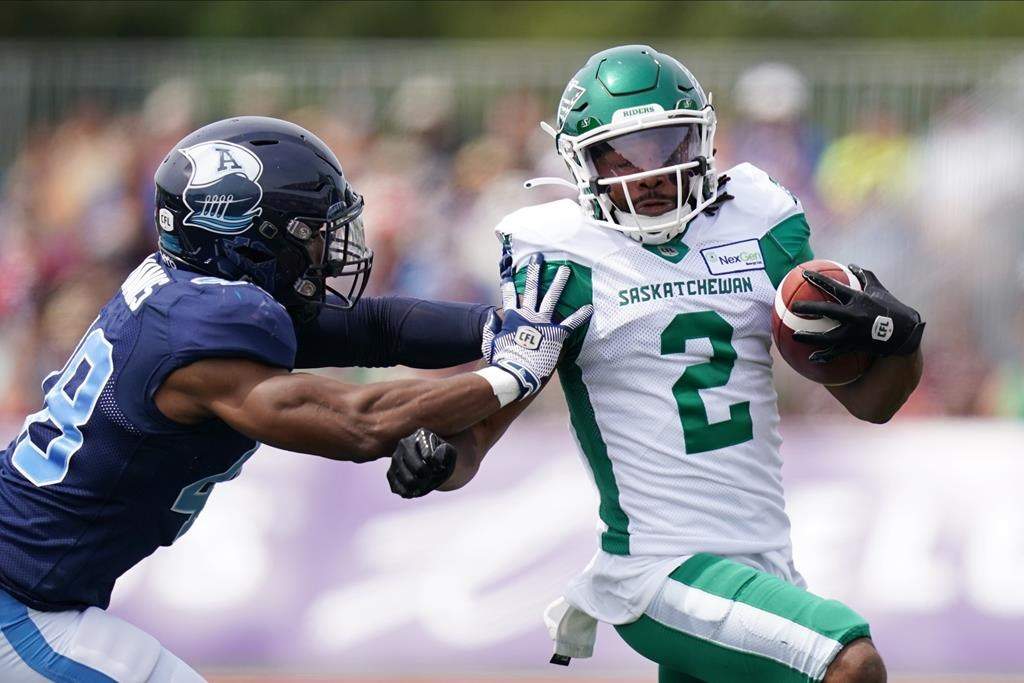 Saskatchewan Roughriders’ Mario Alford, right, avoids a tackle by Toronto Argonauts’ Wynton McManis during the first half of CFL action at Acadia University in Wolfville, N.S., Saturday, July 16, 2022. THE CANADIAN PRESS/Darren Calabrese