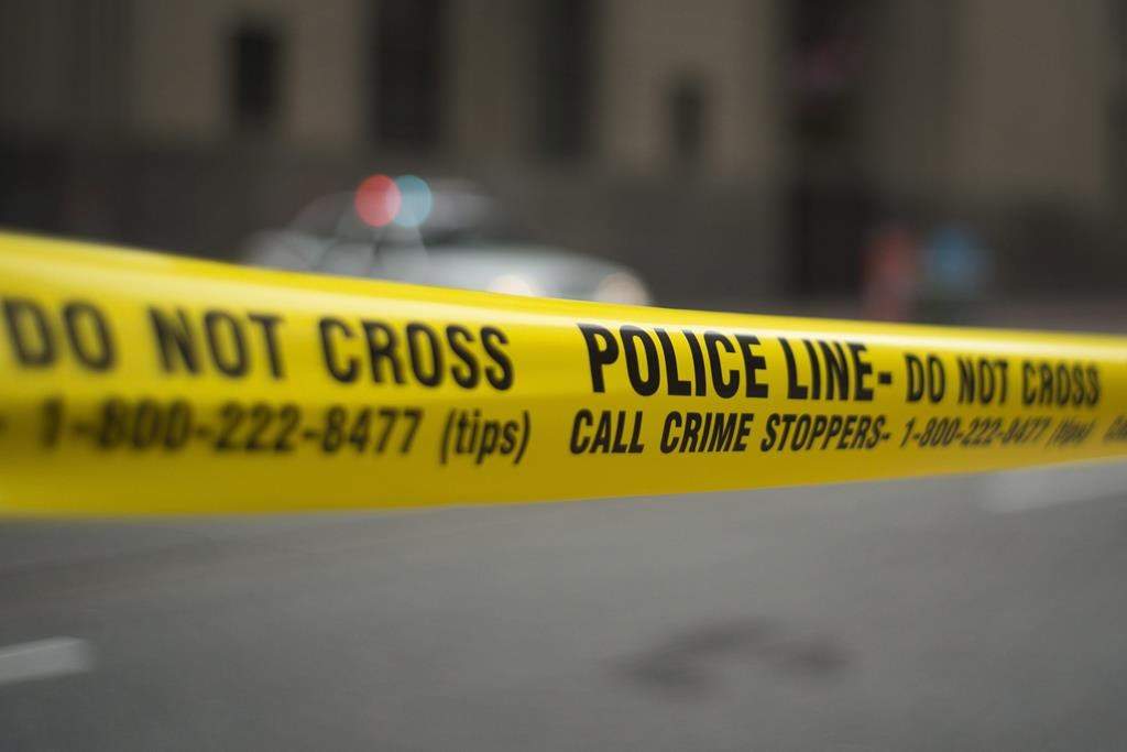 Police tape in front of a blurry background.
