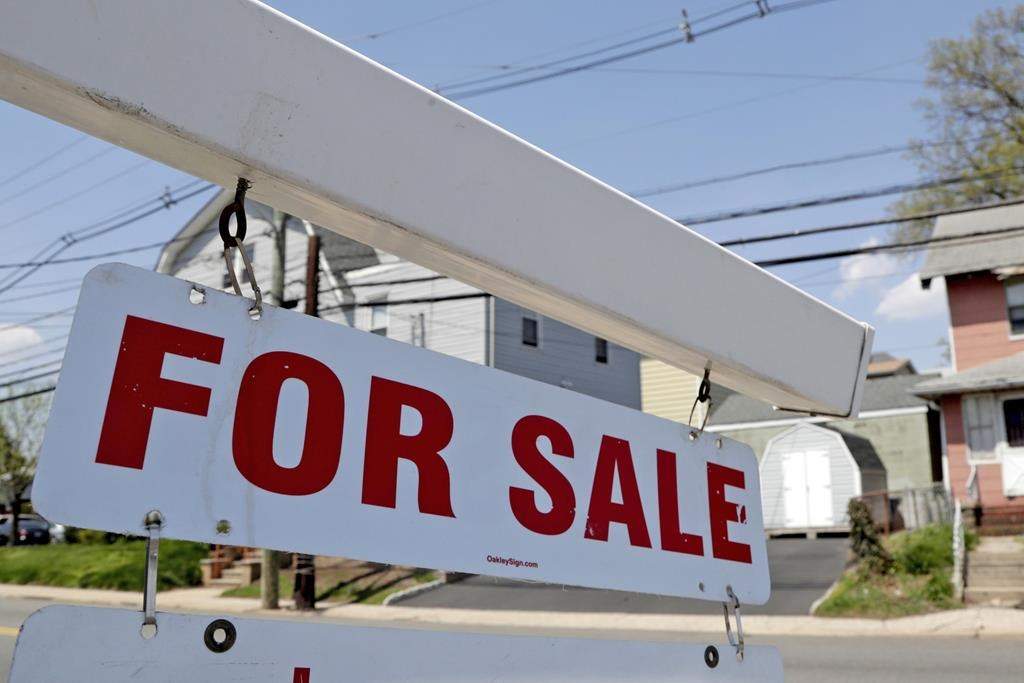FILE - A "for sale" sign hangs from a post outside of a vacant business building in Belleville, N.J., Thursday, May 3, 2018. T.