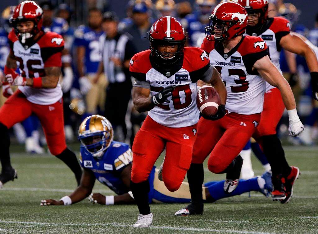 The Calgary Stampeders' Peyton Logan (20) gets the first down against the Winnipeg Blue Bombers during the second half of CFL action in Winnipeg, Friday, July 15, 2022.