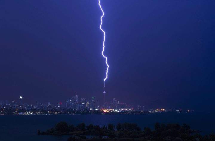 A lightning bolt strikes the CN Tower during a storm in Toronto, early Thursday July 14, 2016. 
