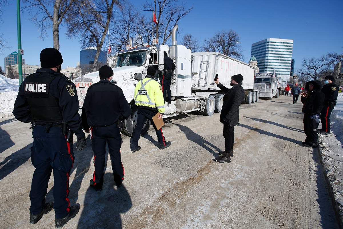 Winnipeg police talk to the lead driver in a convoy of COVID-19 mandate protest trucks as they head home Wednesday, Feb. 23, 2022.