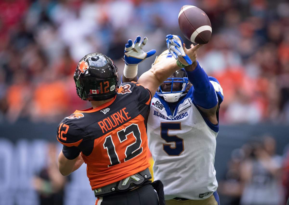 Winnipeg Blue Bombers’ Willie Jefferson (5) blocks a pass attempt by B.C. Lions quarterback Nathan Rourke (12) during the first half of CFL football game in Vancouver, on Saturday, July 9, 2022.