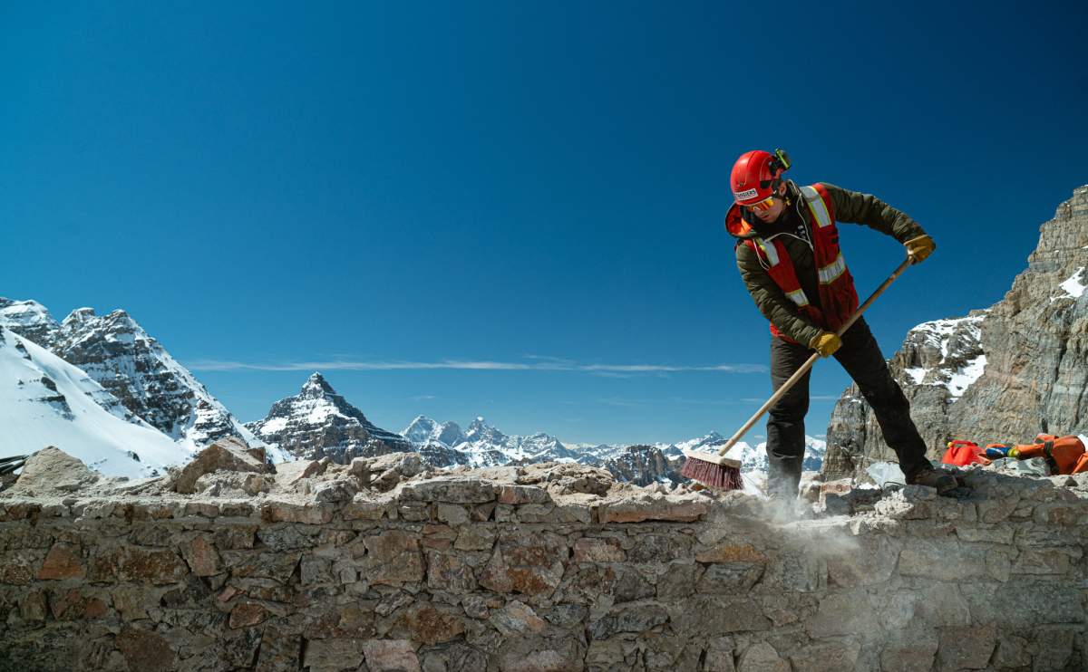 A worker cleans up after the dismantling of the Abbot Pass Refuge Cabin in this undated handout photo.