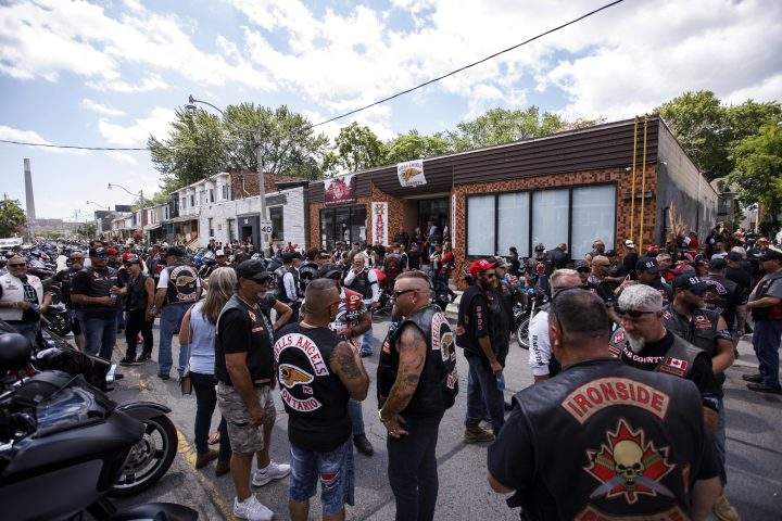 A group of bikers gather outside an east-end storefront in Toronto following a procession to honour longtime Toronto Hells Angels member Donny Petersen, who died in late 2021, Thursday, July 21, 2022.