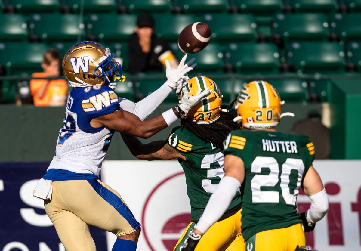 Winnipeg Blue Bombers Rasheed Bailey (88) makes the catch as Edmonton Elks Treston Decoud (37) and Scott Hutter (20) try to stop him.