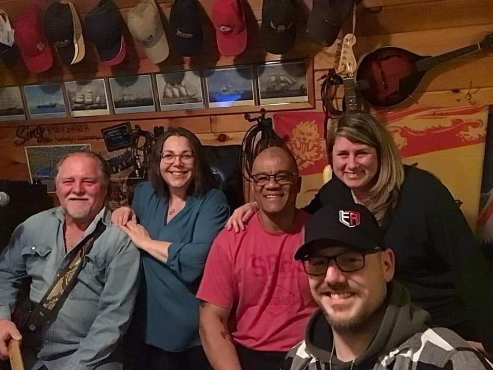 Darrell Richards, middle, sits with members of the band Ryan Drive. Richards, a married father of three, was a bass player with the band.