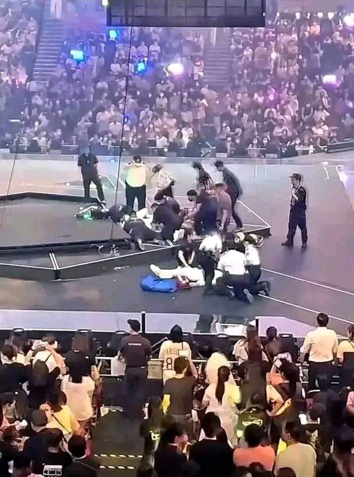Staff surround the injured dancers and fallen screen, trying to provide aid.