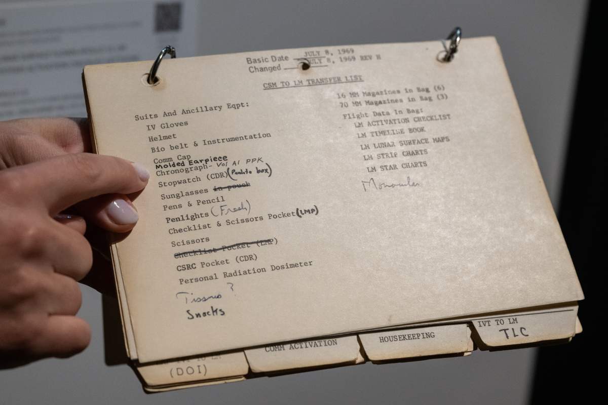 Cassandra Hatton, Senior Vice President, points to handwritten items including, "molded earpiece, tissues and snacks" on Apollo 11 LM Systems Activation Checklist during on display during a press preview at Sotheby's on July 21, 2022 in New York City.