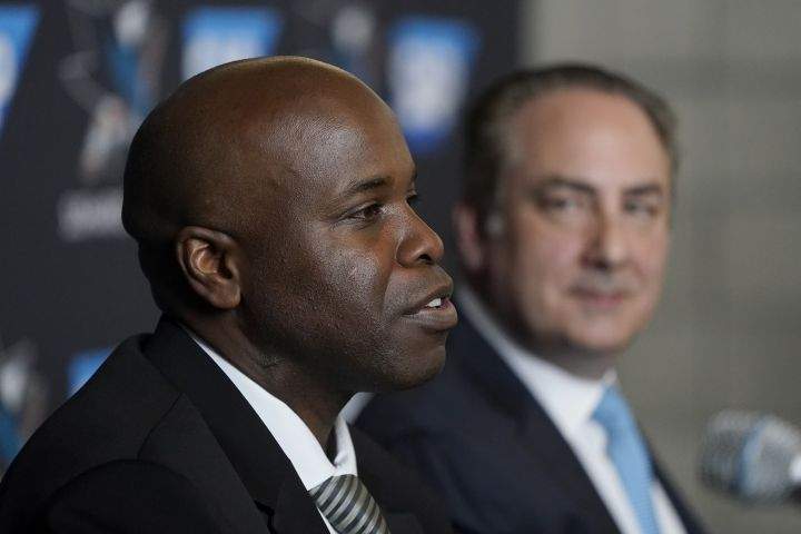 Mike Grier, left, speaks to reporters as he is introduced as the new general manager of the San Jose Sharks next to president Jonathan Becher at a news conference in San Jose, Calif., Tuesday, July 5, 2022.