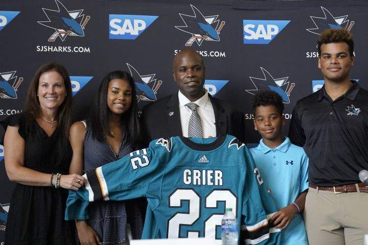 Mike Grier, middle, poses for photos with his wife, Anne, from left, and their children Brooklyn, Tristan and Jayden as Grier is introduced as the new general manager of the San Jose Sharks at a news conference in San Jose, Calif., Tuesday, July 5, 2022.