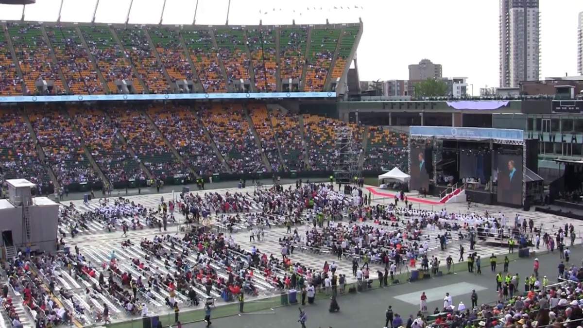 People arrive at Edmonton's Commonwealth Stadium Tuesday, July 26, 2022 for Pope Francis' open-air mass.