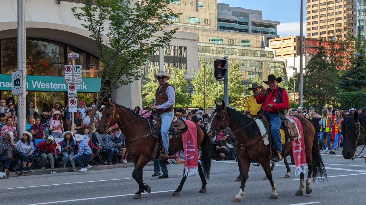 Kevin Costner, the 2022 Calgary Stampede Parade Marshal riding beside honorary pararde marshal, John Scott on July 8, 2022.