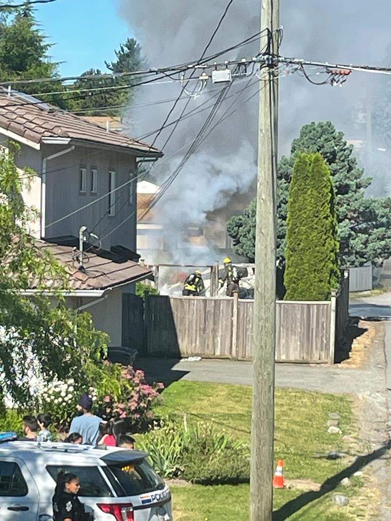Elizabeth McSheffrey Firefighters extinguish a vehicle fire outside a home in the 8200-block of 128 Street in Surrey, B.C. Mounties were called to the address on Thurs. July 14, 2022, and found a man suffering from gunshot wounds. He died of his injuries at the scene.