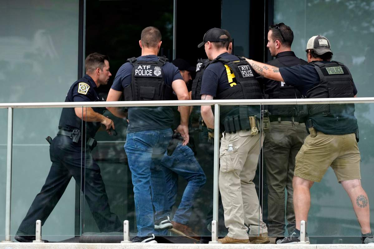 Law enforcement search as they walk into a building after a mass shooting at the Highland Park Fourth of July parade in downtown Highland Park, a Chicago suburb on Monday, July 4, 2022.