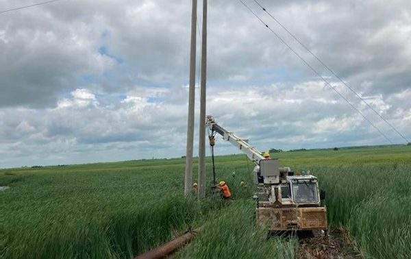 Manitoba Hydro workers repair a hydro pole Tuesday.