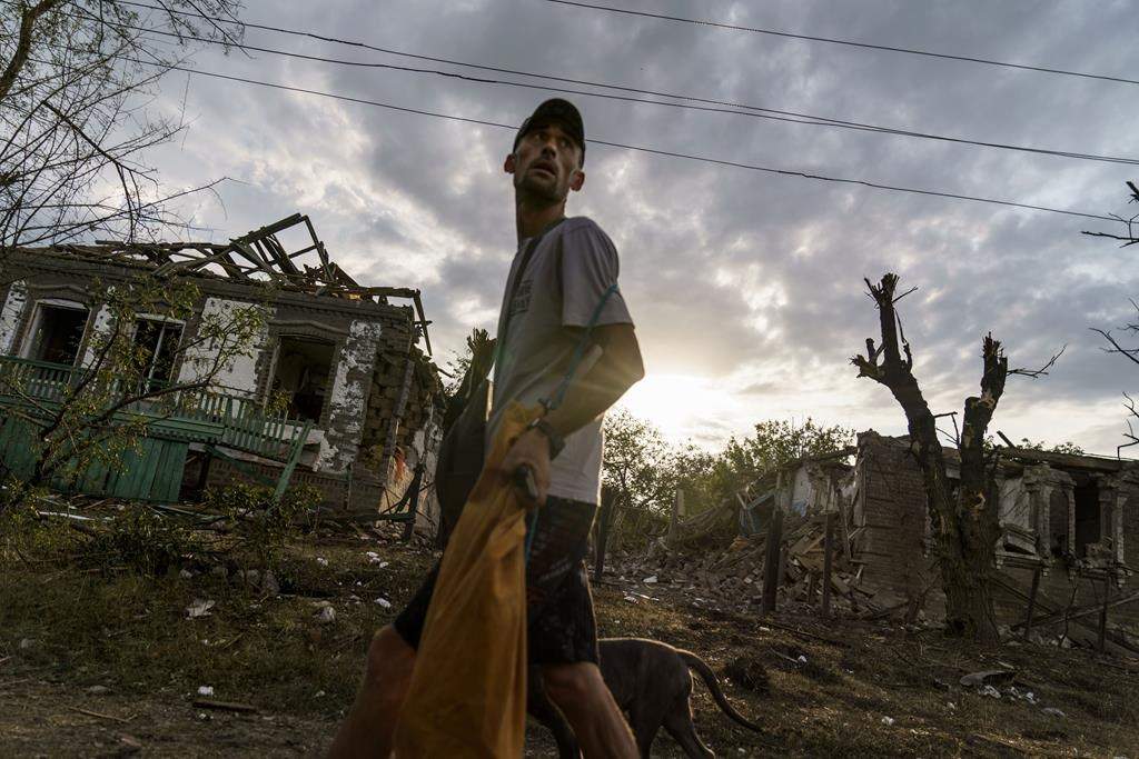 A person walks past the damaged homes from a rocket attack in the morning of Aug. 16 in Kramatorsk, eastern Ukraine, as Russian shelling continued to hit towns and villages in Donetsk province, regional officials said.