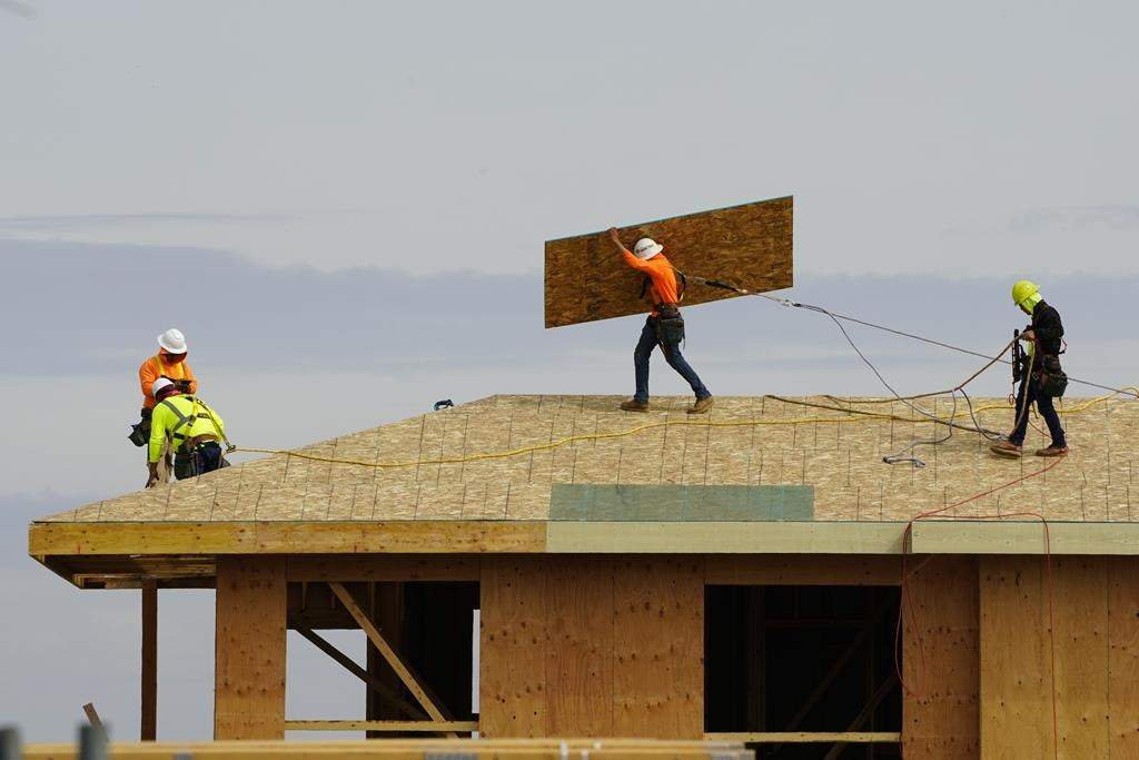 FILE - Work is done on the roof of a building under construction.