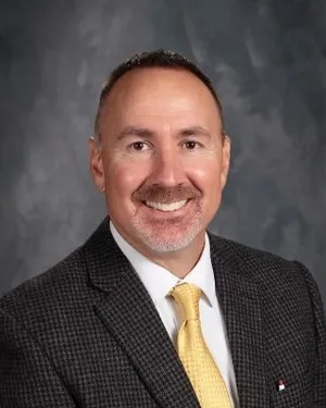 Merlyn Johnson smiling in a suit and tie.
