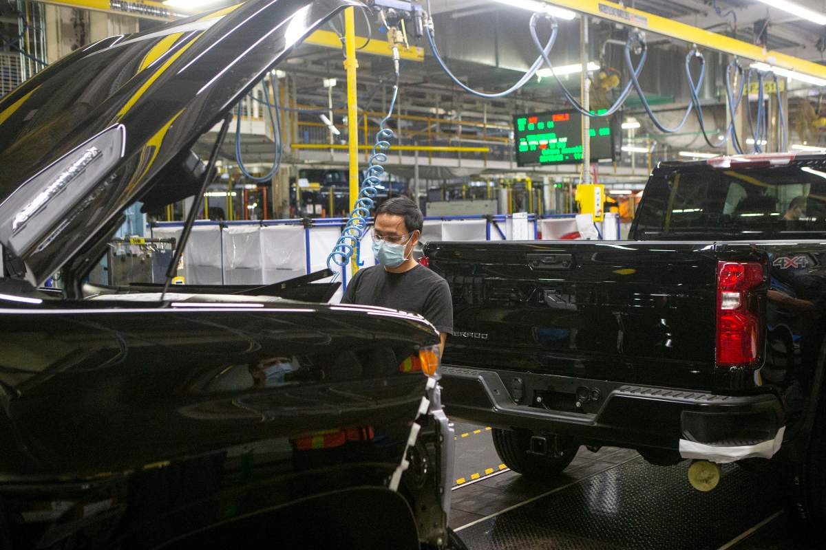 FILE - An auto worker is seen on the General Assembly line  producing the Chevrolet Silverado, at the GM plant in Oshawa, Ontario, on Tuesday, February 22 2022.