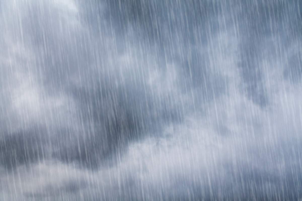 A grey, dark sky full of clouds and torrential rain