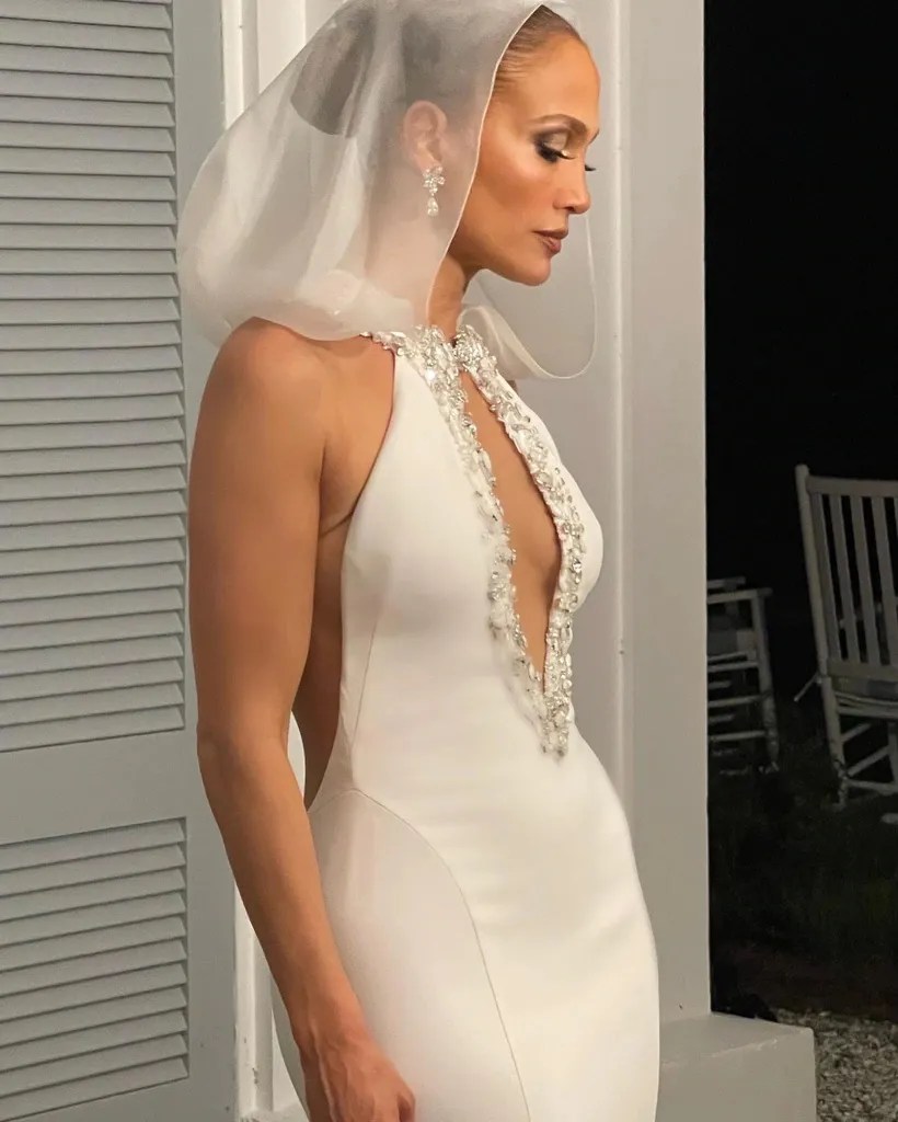Jennifer Lopez stands in her second gown with a short veil.