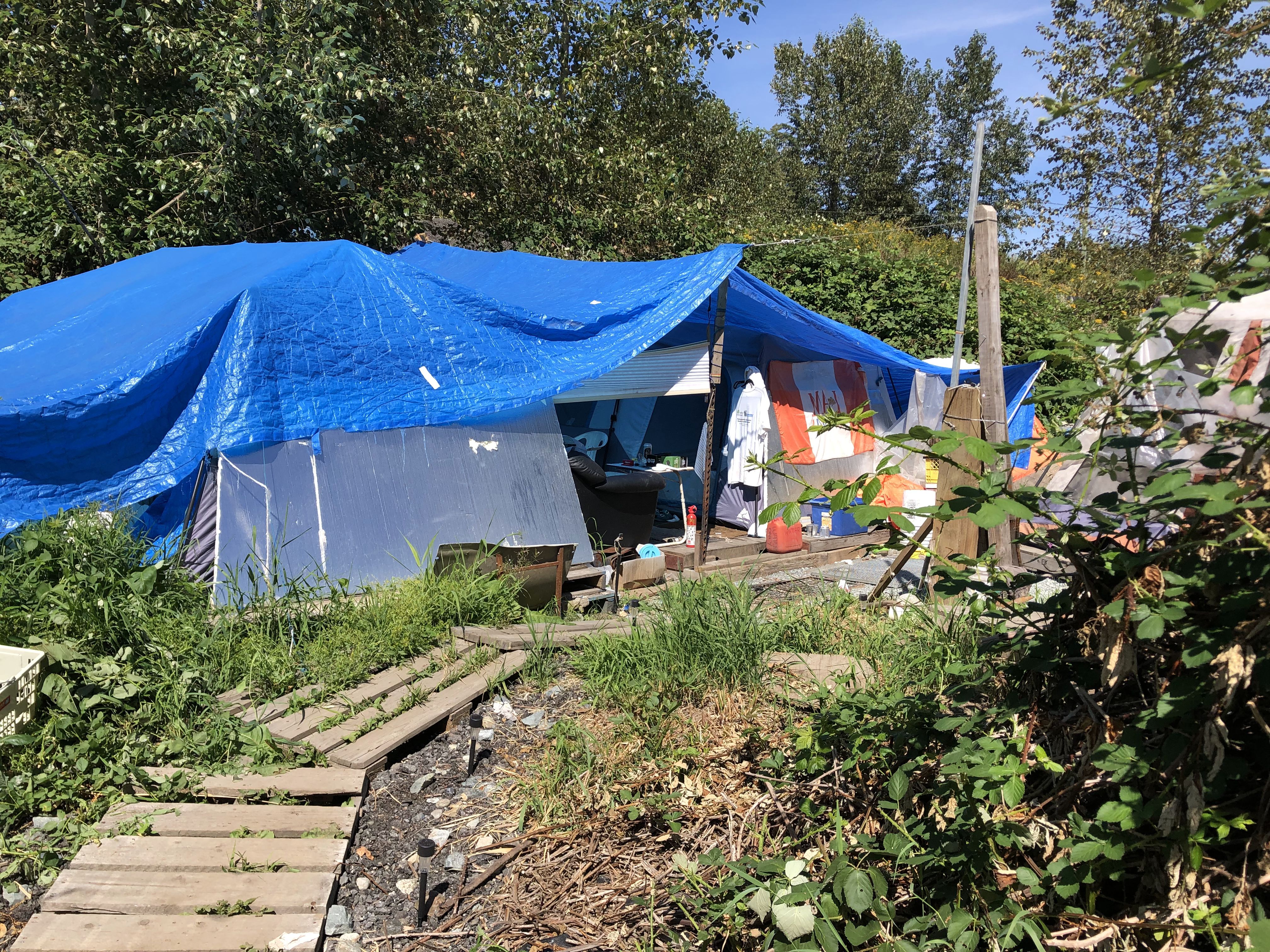An encampment under the Trans Canada highway in Abbotsford, BC. Daytime temperatures in the Fraser Valley are higher than along the coast, and in a tent, it can be especially hot.