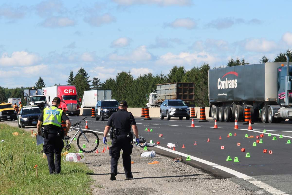 Police at the scene of a fatal collision on Highway 401 involving a cyclist and a vehicle in the eastbound lane near Colonel Talbot Road, London, Ont., on Thursday.