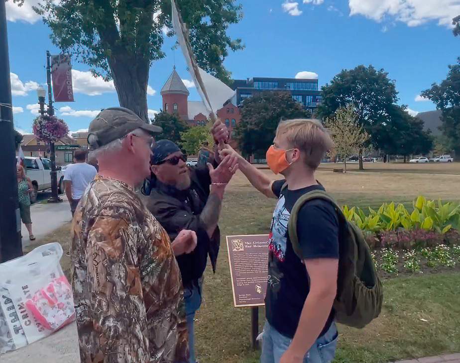 A man grabs the sign from a counter-protester at Confederation Park on Aug. 13, 2022. The incident occurred prior to followers of Romana Didulo attempted to arrest Peterborough Police Service officers.