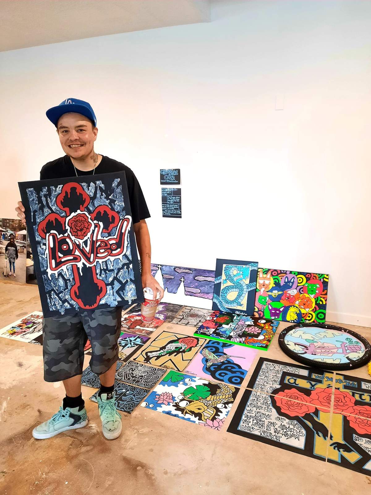 Criss Blake Cook holds his ‘Loved” piece before he sold it to a buyer he could connect with.
