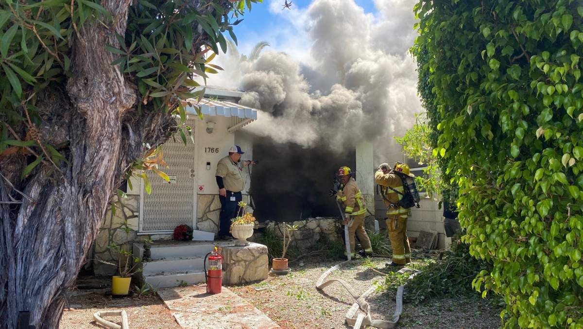 Lynne Mishele's home with smoke barreling from a large hole.