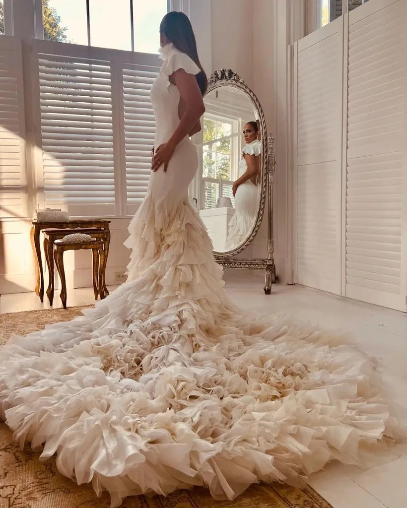 Jennifer Lopez in her dress, standing in front of a mirror.