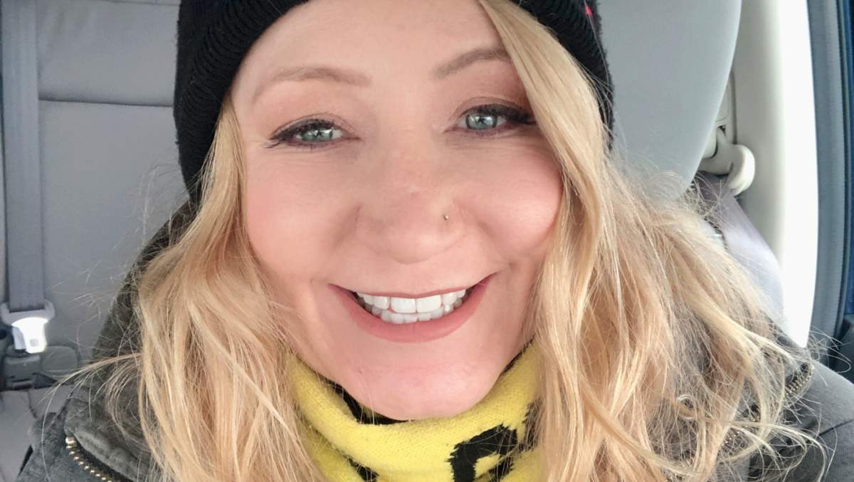 Lynne Mishele, smiling in a beanie and scarf.