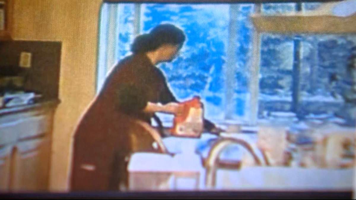 Dr. Yue Yu seen in a screengrab from video opening a bottle of Drano in the kitchen.