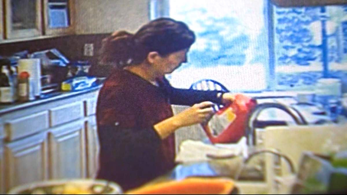 Dr. Yue Yu seen in a screengrab from video opening a bottle of Drano in the kitchen.
