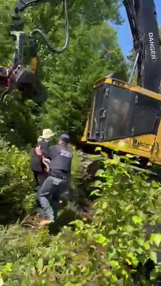 A video sent to Global News shows crews nearly running over a protester who stood in front of a moving machine before they were pulled to safety by a security officer.