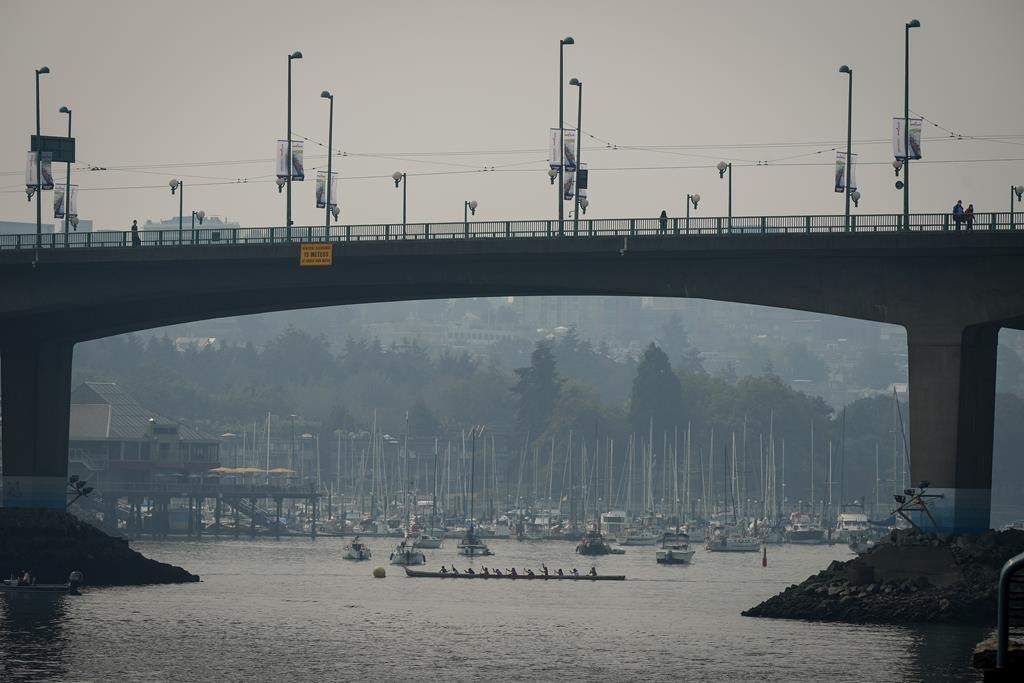 Smoke fills the air as paddlers in an Indigenous war canoe prepare for a race on False Creek during the Four Fires Festival in Vancouver, on Sunday, Sept. 11, 2022. Environment Canada issued an air quality advisory for Metro Vancouver and the Fraser Valley advising people to avoid the outdoors due to wildfires burning near Chilliwack, Hope and in the U.S. 