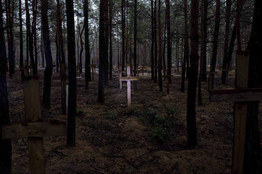 A view of unidentified graves of civilians and Ukrainian soldiers in a cemetery in the recently retaken area of Izium, Ukraine, Thursday, Sept. 15, 2022 who had been killed by Russian forces near the beginning of the war. A mass grave of Ukrainian soldiers and unknown buried civilians was found in the forest of recently recaptured city of Izium. (AP Photo/Evgeniy Maloletka)