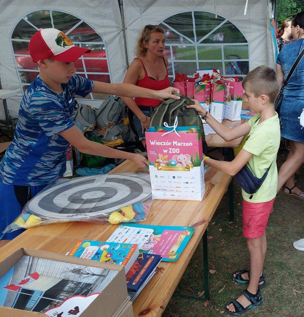 Oscar Oliver handing backpack and gifts to a young Ukrainian refugee.
