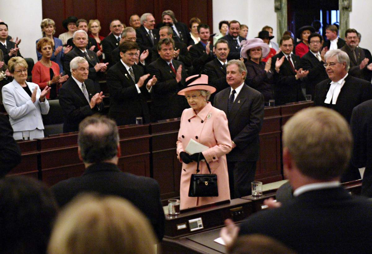 Queen Elizabeth II is applauded as she leaves the Alberta Legislature followed by Alberta Premier Ralph Klein in Edmonton, Tuesday, May 24, 2005. The Queen is in Alberta to celebrate the province’s centennial. (CP PHOTO/Paul Chiasson)