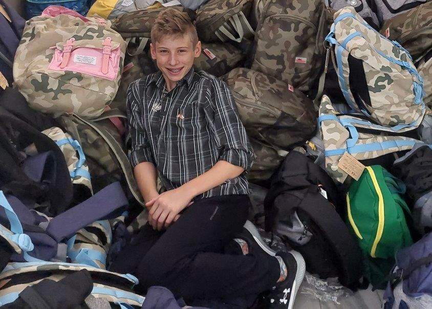 Oscar Oliver on top of 350 filled backpacks.