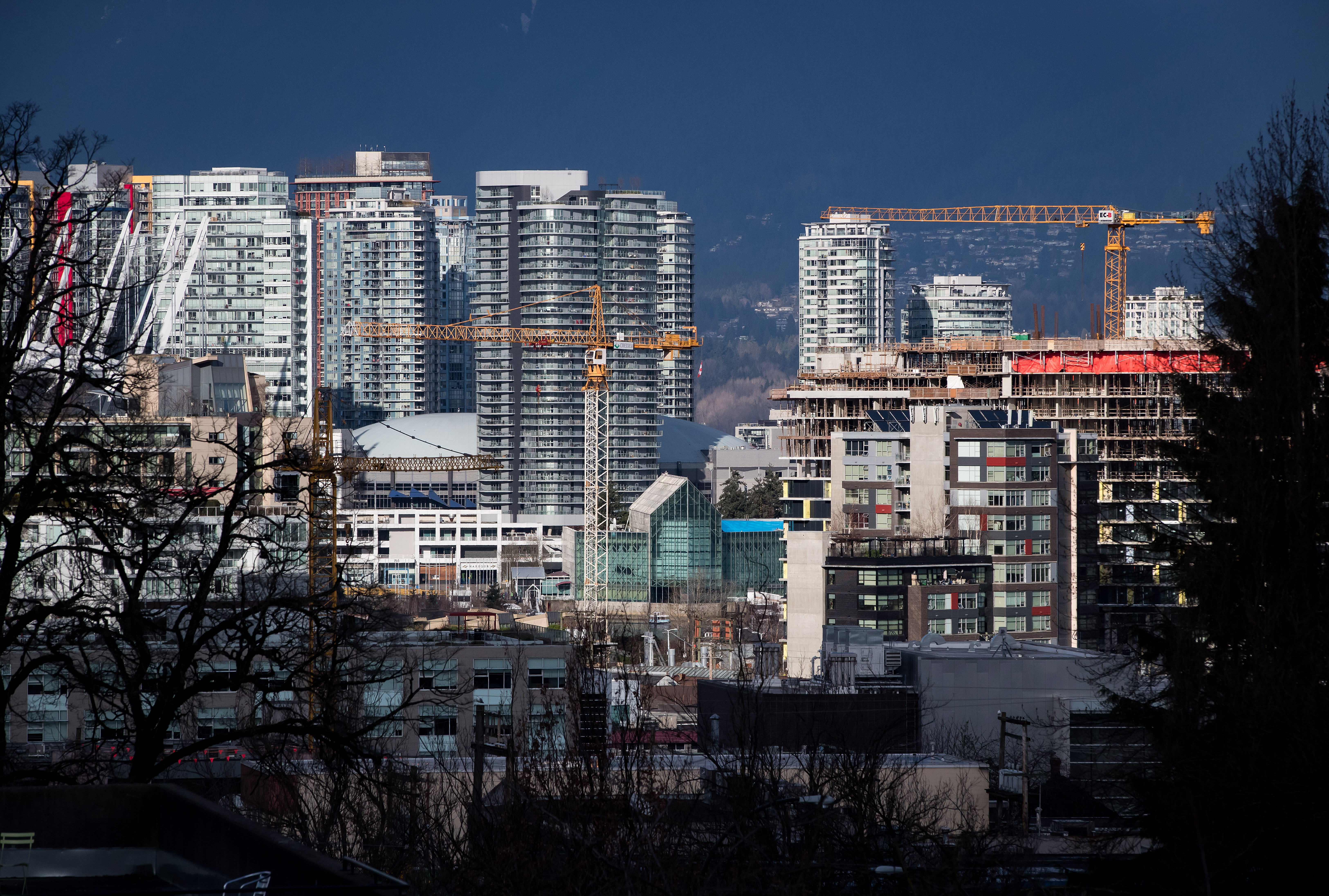 Construction cranes tower above condos under construction near southeast False Creek in Vancouver on February 9, 2020. There is a growing push to wean buildings off polluting sources of energy.