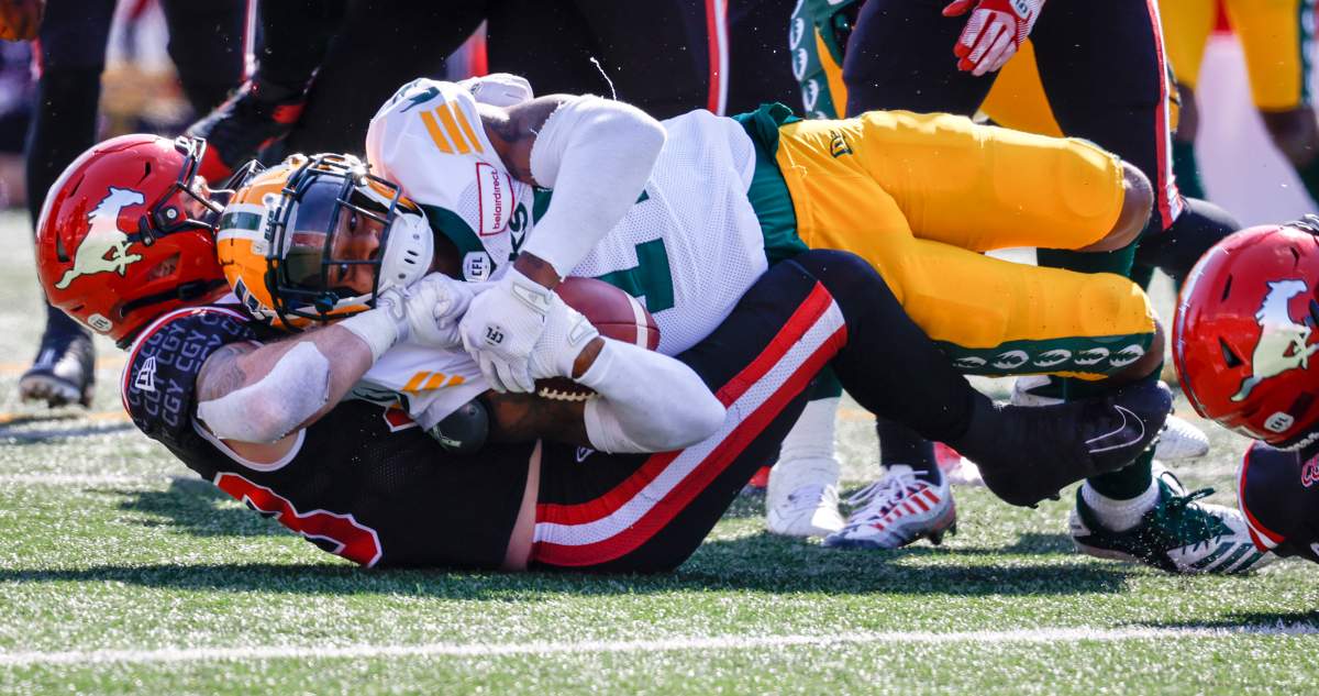 Edmonton Elks receiver Dillon Mitchell, right, is sacked by Calgary Stampeders linebacker Charlie Moore during first half CFL football action in Calgary, Alta., Monday, Sept. 5, 2022.