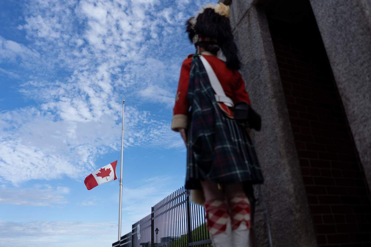 The Canadian flag flies at half-mast as a guard in traditional dress stands at the Halifax Citadel in Halifax, N.S. following the passing of Queen Elizabeth II on Thursday, September 8, 2022. THE CANADIAN PRESS/Darren Calabrese