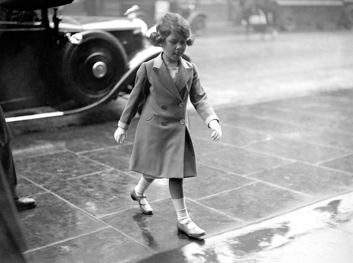 Princess Elizabeth walks through the rain to visit the Royal Tournament at Olympia in London in 1932.